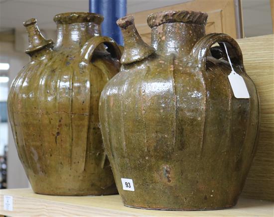 Two similar 17th century French, Auvergne, terracotta spouted jars, 14in. and 15.5in.